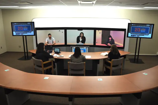 Telepresence classroom with six people in a video meeting.