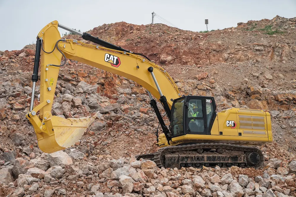 Yellow excavator working on rocky terrain.