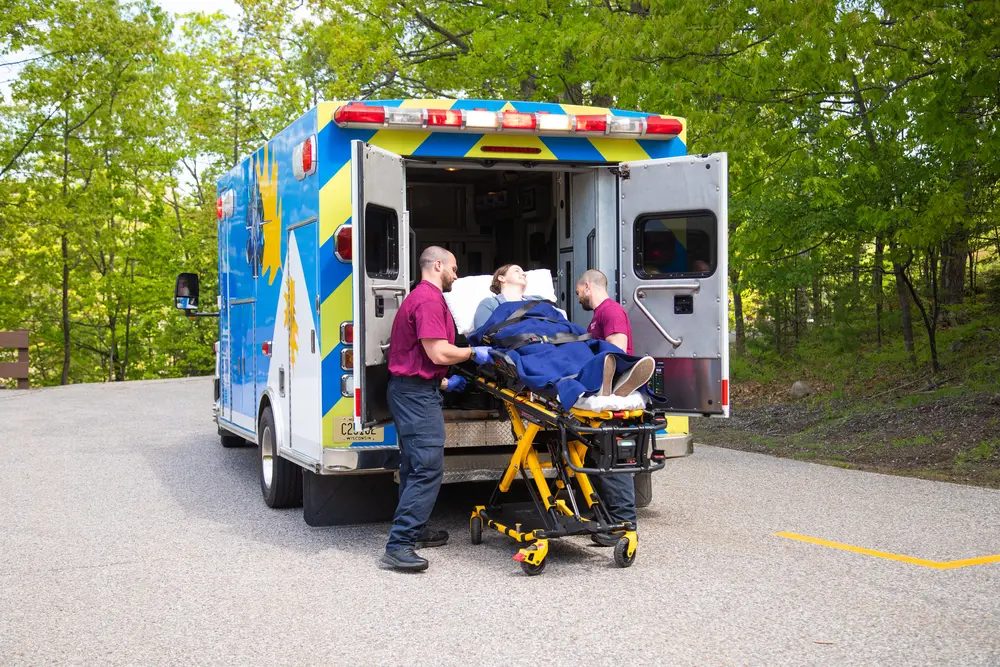 EMS Responder students taking a patient out of ambulance on stretcher.