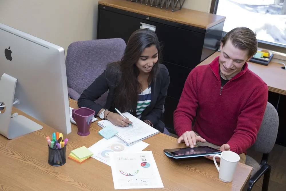 Two people at a desk doing entrepreneurial things.