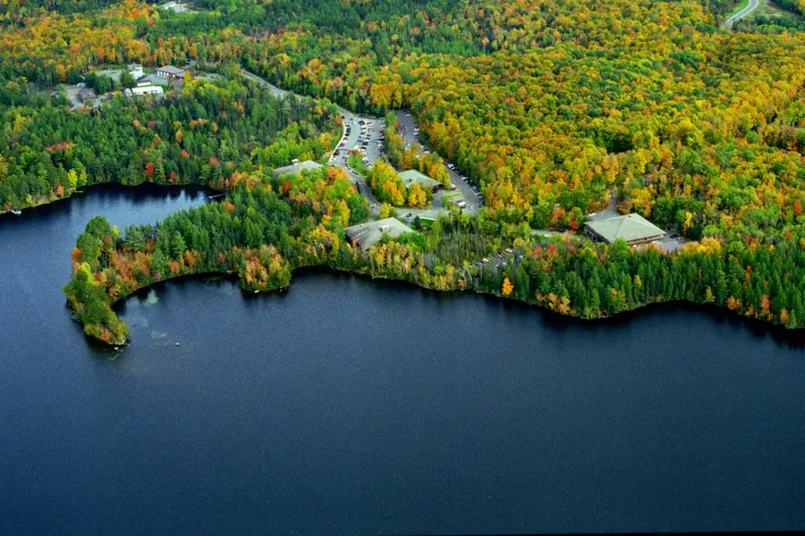 Aerial view of a Lake Julia and Nicolet College campus surrounded by autumn-colored forest.