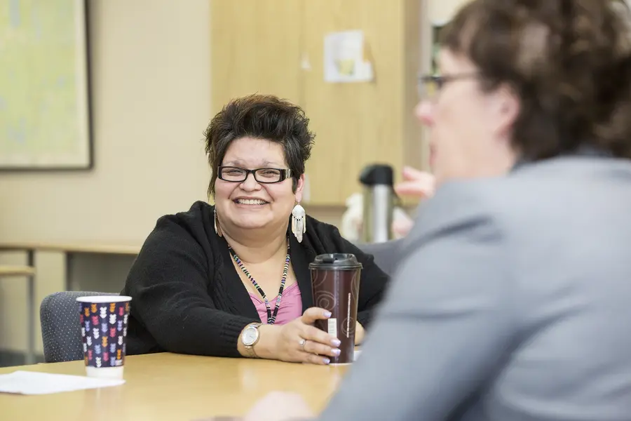 Business Management student in Mole Lake smiling while instructor speaks. 
