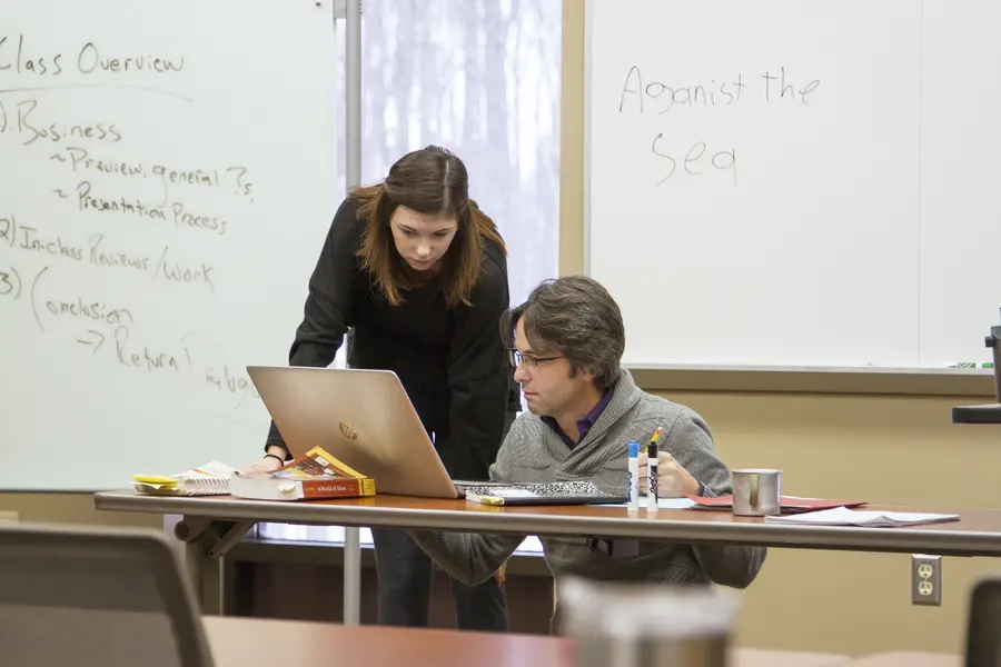 Student and instructor working together with lap top